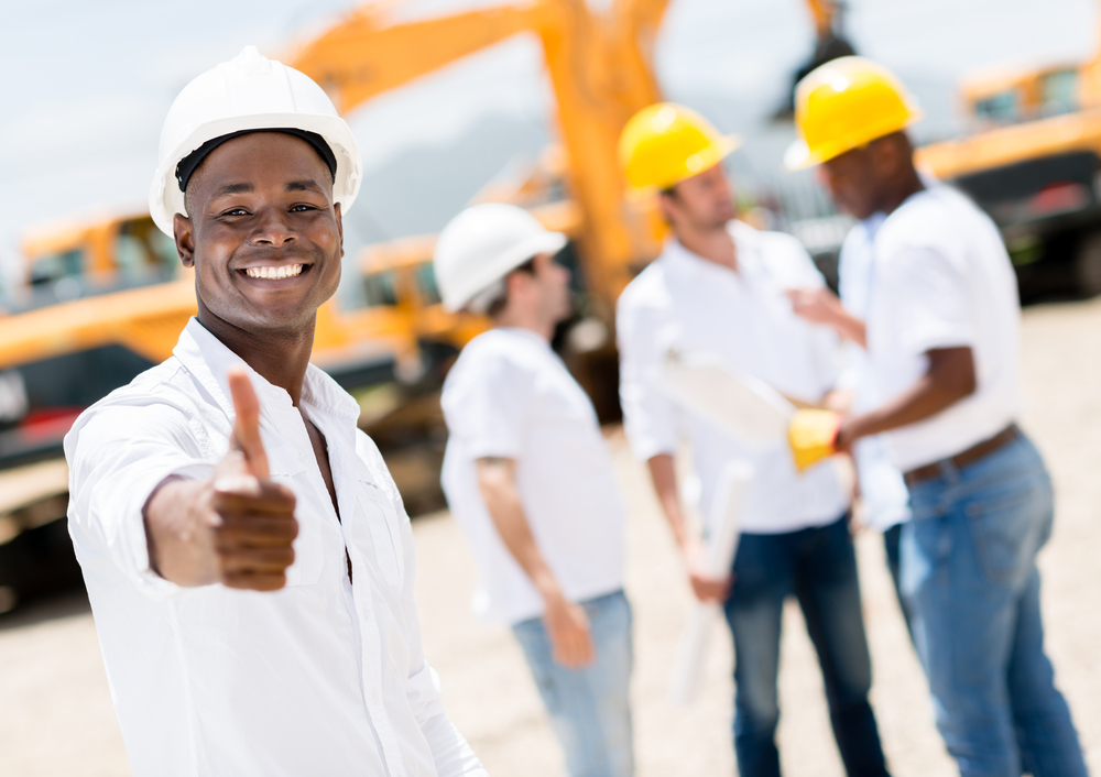 Happy engineer with thumbs up at a construction site