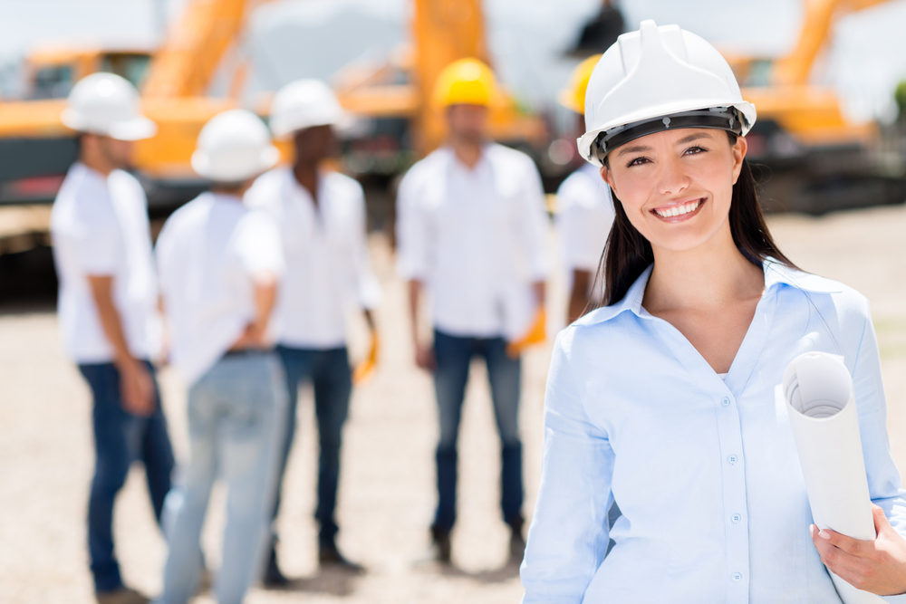 Female architect at a construction site looking happy